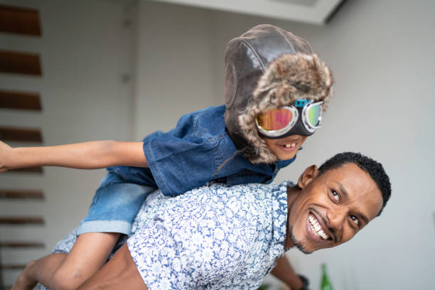 istock Boy with pilot glasses play fly with his dad at home 1138489163