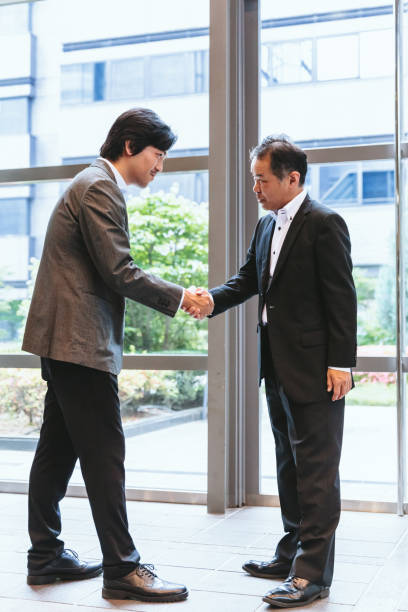 istock two Japanese men shaking their hands in agreement 1138489328