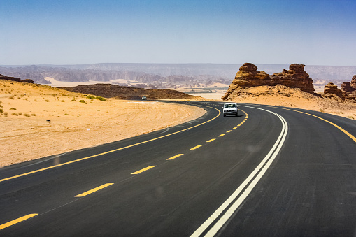 Stock photograph of a road leading to Al Ula, Medina Region, Saudi Arabia on a sunny day.