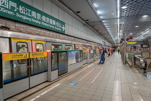 Taipei, Taiwan - February 2019: Taipei MRT  station platform and passengers waiting. Taipei Metro, is a metro system serving Taipei.
