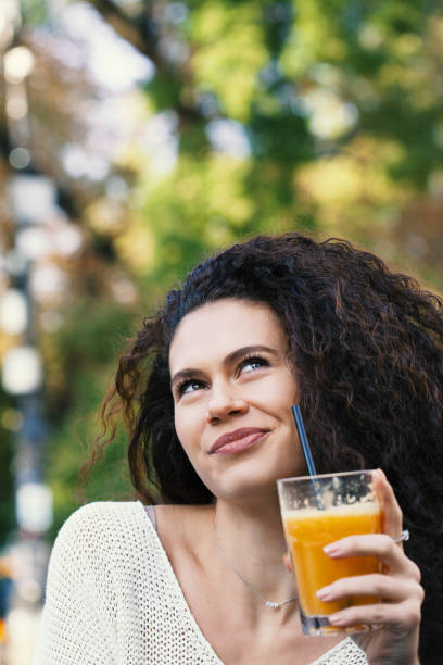 istock Beautiful young woman drinking orange juice 1138500105
