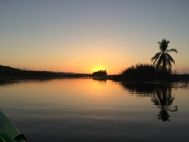 atardecer sobre el lago de costa rica con agua y cielo reunión en la tierra - costa rican sunset fotos fotografías e imágenes de stock