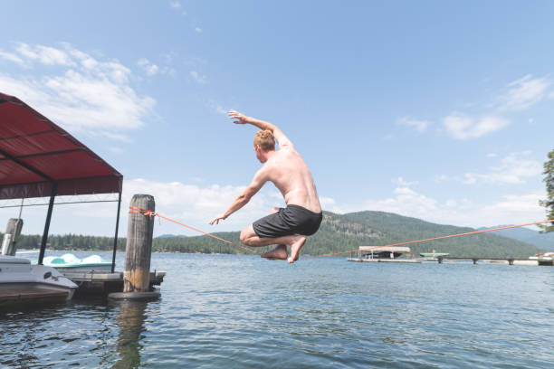istock Young man balancing on a slackline over a lake 1138506932