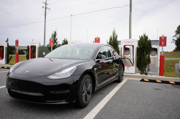 voiture de tesla à la station de compresseur près de l'interstate - supercharger photos et images de collection