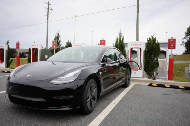 Tesla car at supercharger station near interstate Live Oak, Florida, USA - January 19, 2019: Vehicle charging at Tesla Supercharger station located at the Busy Bee fuel station north of Interstate 10 Exit 283 near Live Oak, Florida. supercharged engine stock pictures, royalty-free photos & images