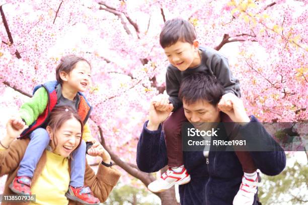 満開の桜と30代の夫婦と2人の子供