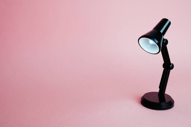 istock Black desk lamp isolated on pink background 1138508980
