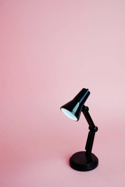 istock Black desk lamp isolated on pink background 1138508986