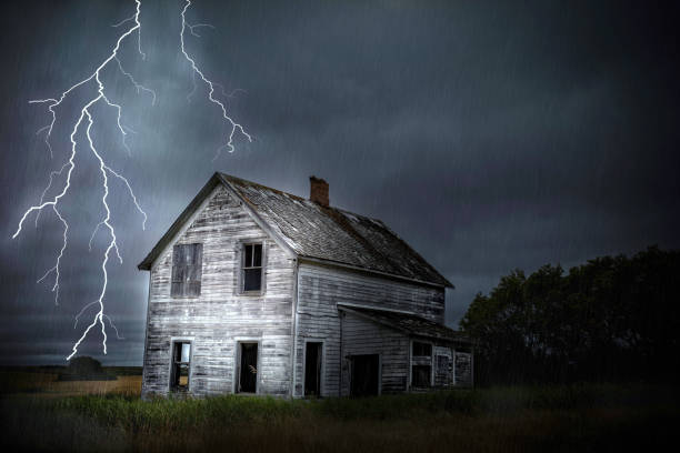 heavy lightning  and thunder storm close to abandoned house. horizontal image of  a very dark and heavy thunder and lightning storm at night with rain pouring down on an old abandoned house sitting in the rural country side in the summer. haunted house stock pictures, royalty-free photos & images