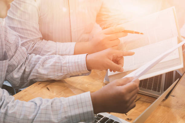 istock Team work succes of young business managers working with new startup project in modern office.Analyze document, plans. Holding papers and book, vintage color,selective focus 1138510505
