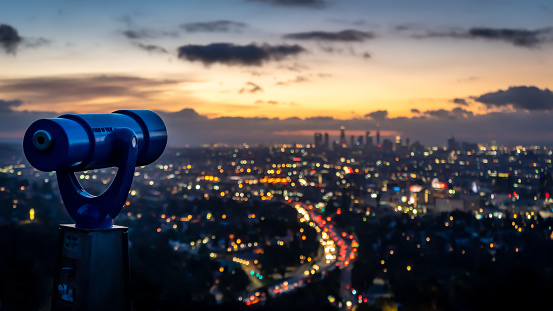 A tower viewer in the foreground overlooking the LA skyline just before sunrise