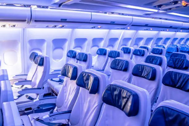 Passenger Cabin economy class of wide fuselage aircraft, a.k.a. two aisles. Aircraft with led lighting triggered in color display mode.