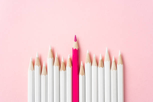 color pencil with leadership, teamwork concept Business and design concept - lot of white pencils and one color pencil on pink paper background. It's symbol of leadership, teamwork, success and unique. standing out from the crowd stock pictures, royalty-free photos & images