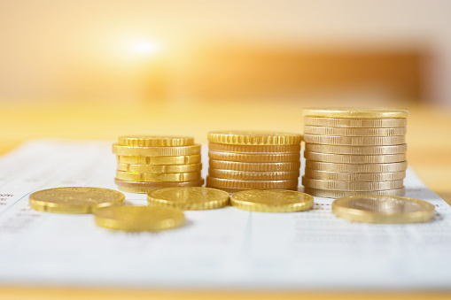 Saving stack coins money concept,graph,chart document and pen on desktop desk in hipster office,copy space.selective focus,vintage color