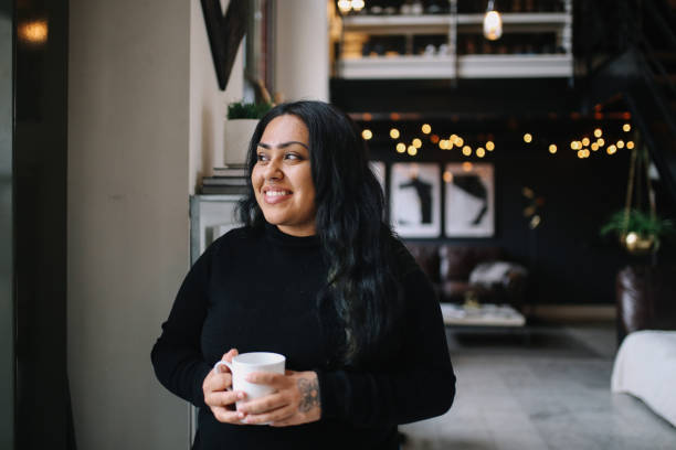portrait d'une jeune femme ayant le café dans son appartement du centre-ville de los angeles - native habitat photos et images de collection