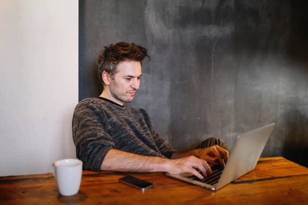 istock Young man finishing work at home on his laptop 1138528484