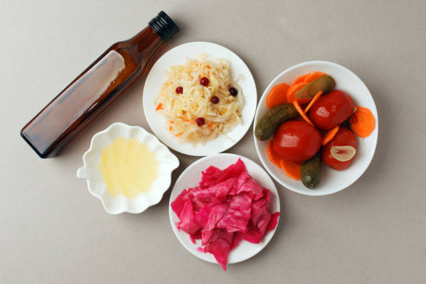 istock Fermented vegetables on plate on gray background: sauerkraut, pickled cabbage with beetroot, pickled cucumbers, carrots and tomatoes. Vegetarian food concept 1138531094