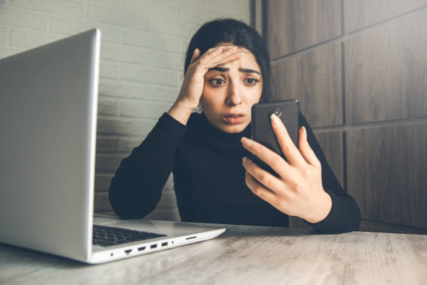 istock sad woman hand phone in office desk 1138532448
