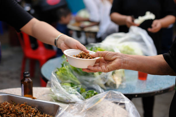 istock Starvation concept : Rich people give food to the poor. 1138541386