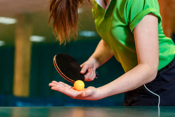 pagaia da ping pong nera e palla in mani femminili vicine. servire la palla nel ping pong - table tennis foto e immagini stock