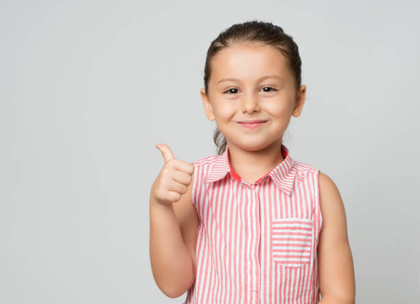 Little girl giving thumbs up Little girl giving thumbs up 6 7 years stock pictures, royalty-free photos & images