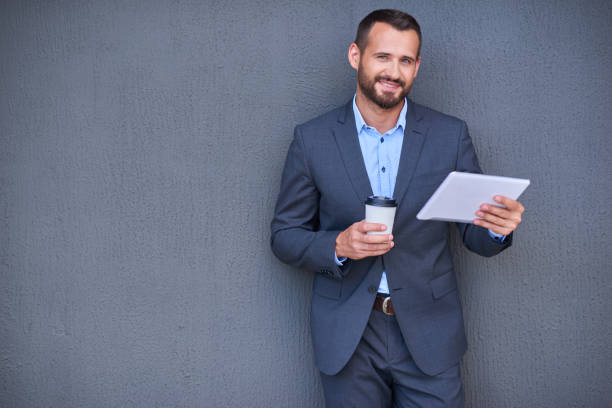 istock Businessman in suit with tablet and cup 1138545558
