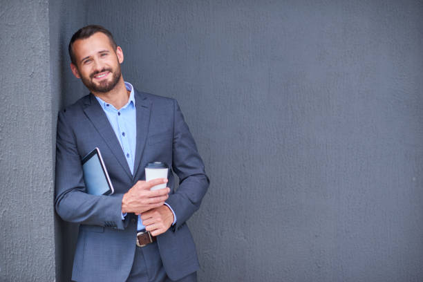 istock Businessman in suit with tablet and cup 1138546597