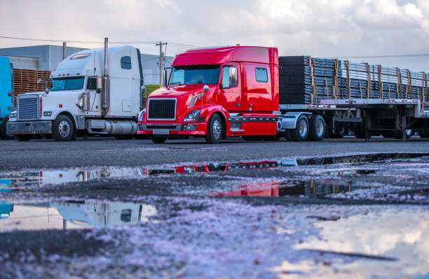 Different big rigs semi trucks with commercial cargo on semi trailers standing on the parking lot in row Different bonnet makes and models of professional big rigs semi trucks with commercial cargo on semi trailers standing in row on the industrial parking lot near the warehouse waiting for unloading car carrier semi stock pictures, royalty-free photos & images