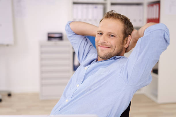Young Asian business man sitting by the desk at work and rest one's eyes, concept for hard work in an organization. The picture blury.