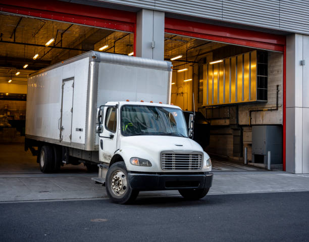 półciężarówka z przyczepą skrzynkową opuszcza bramę budynku wielowarstwowego po rozładowaniu dostarczonego ładunku - semi truck vehicle trailer truck empty zdjęcia i obrazy z banku zdjęć