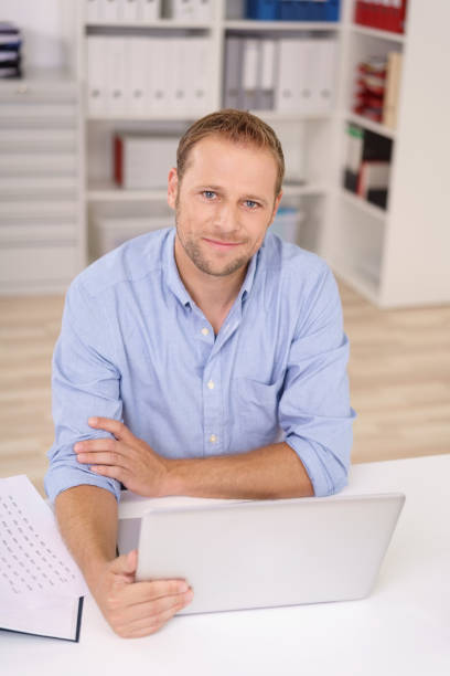 istock Friendly businessman sitting at his desk 1138551333