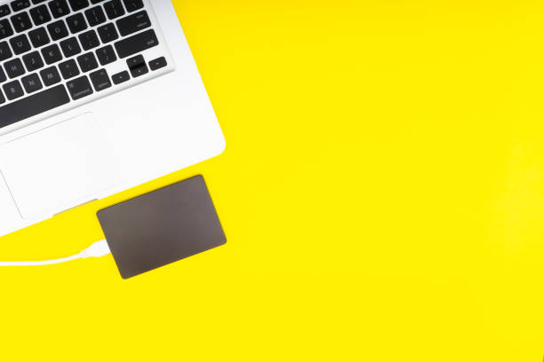 istock Laptop keyboard, storage drive or hard disk on yellow background 1138552498