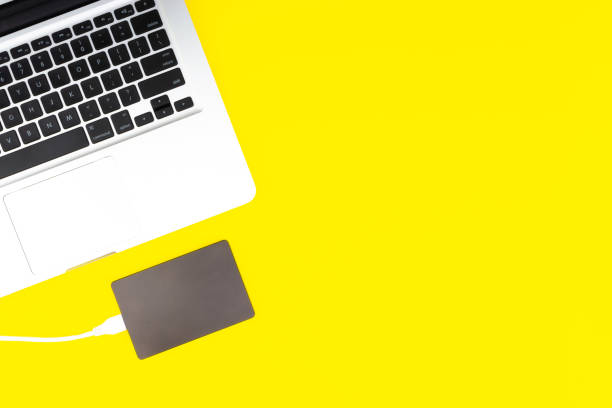 istock Laptop keyboard, storage drive or hard disk on yellow background 1138552535