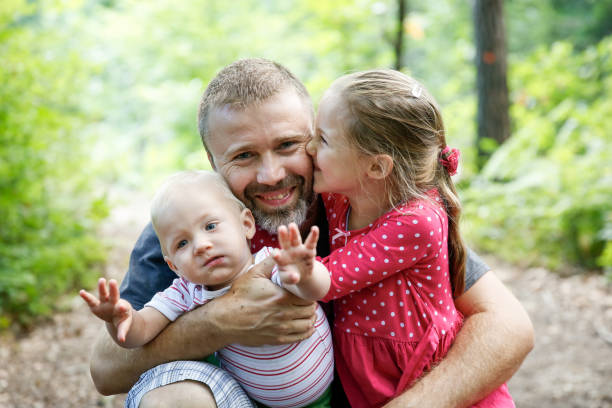 istock Devoted father hugging his son and daughter, enjoying the outdoor. 1138555462