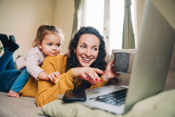 istock Mother and daughter using laptop on sofa 1138556357