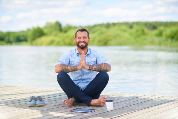 moderner geschäftsmann in lässiger kleidung mit digitaler tablet-meditation - zen like meditating yoga business stock-fotos und bilder