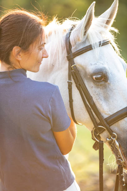 istock Woman hugging her mare and smiling 1138556790