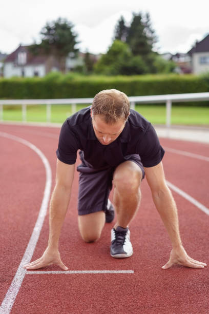 istock Athletic man on the starter grid on a race track 1138557798