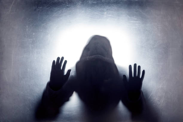 istock Ghostly figure behind a dusty scratched glass 1138557926