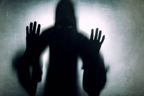 istock Ghostly figure behind a dusty scratched glass 1138557929