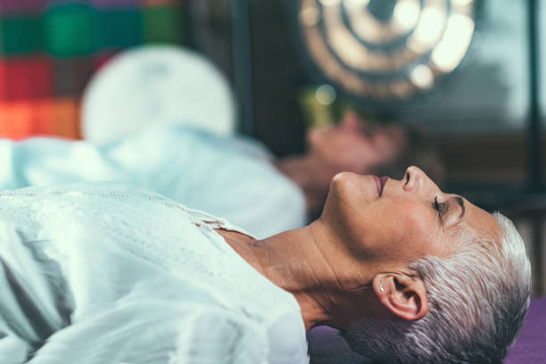 terapia guiada da meditação, mulher sênior no foco - relaxation lying on back women meditating - fotografias e filmes do acervo
