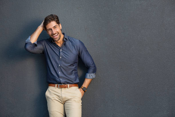 Cheerful young man laughing Portrait of smart business man standing and laughing against gray wall. Confident entrepreneur feeling excited on success and looking at camera. Young businessman in casual clothing smiling isolated on grey background with copy space. handsome people stock pictures, royalty-free photos & images