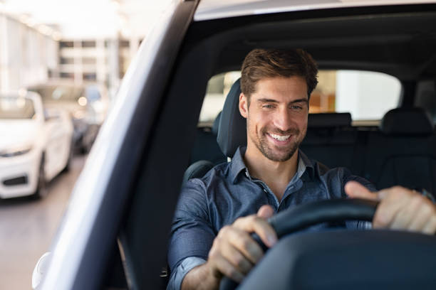 prova di guida presso la concessionaria di auto - car driving men business foto e immagini stock