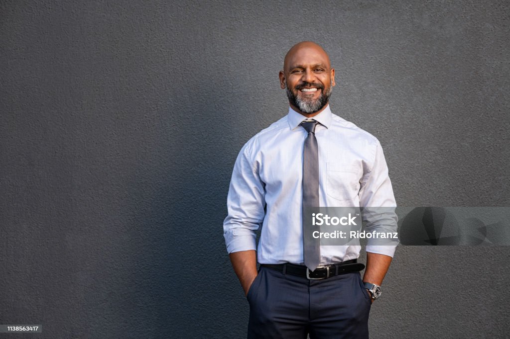 Hombre de negocios afroamericano sonriendo en gris - Foto de stock de Africano-americano libre de derechos