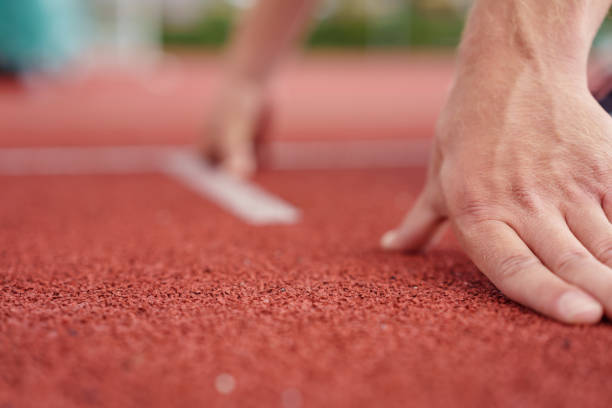 mani di un atleta su una pista - starting hand foto e immagini stock