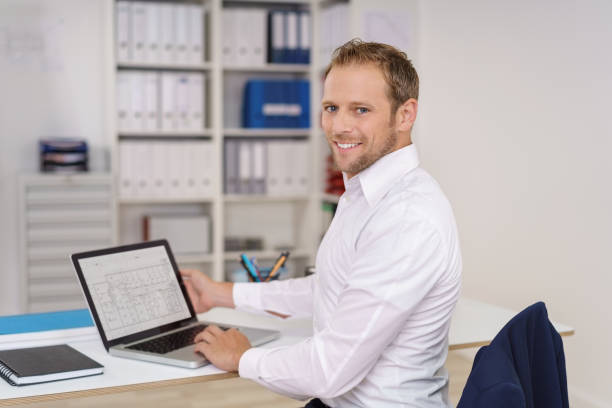 istock Happy young businessman working on a spreadsheet 1138564295