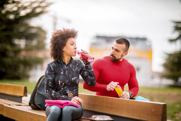 istock Young athletic couple hydrating themselves while taking a break after exercising in a city park 1138566272