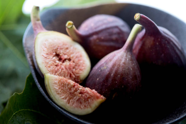 istock Fresh figs in a a bowl with fig leaf on white table 1138569027