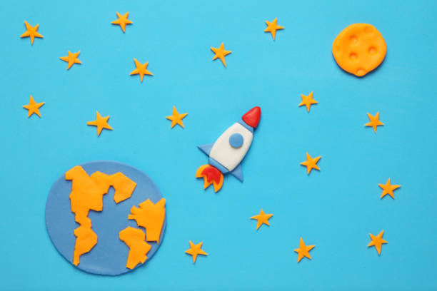 istock Creative craft plasticine rocket in open space, astronaut dreams. Stars, planet earth and moon. Cartoon art 1138569750