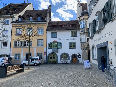 Schaffhausen, Switzerland - March, 13 - 2019: Part of the market square, called Herrenacker. In the center the inn of peace, Wirtschaft zum Frieden, to be seen. The house was built in 1445.